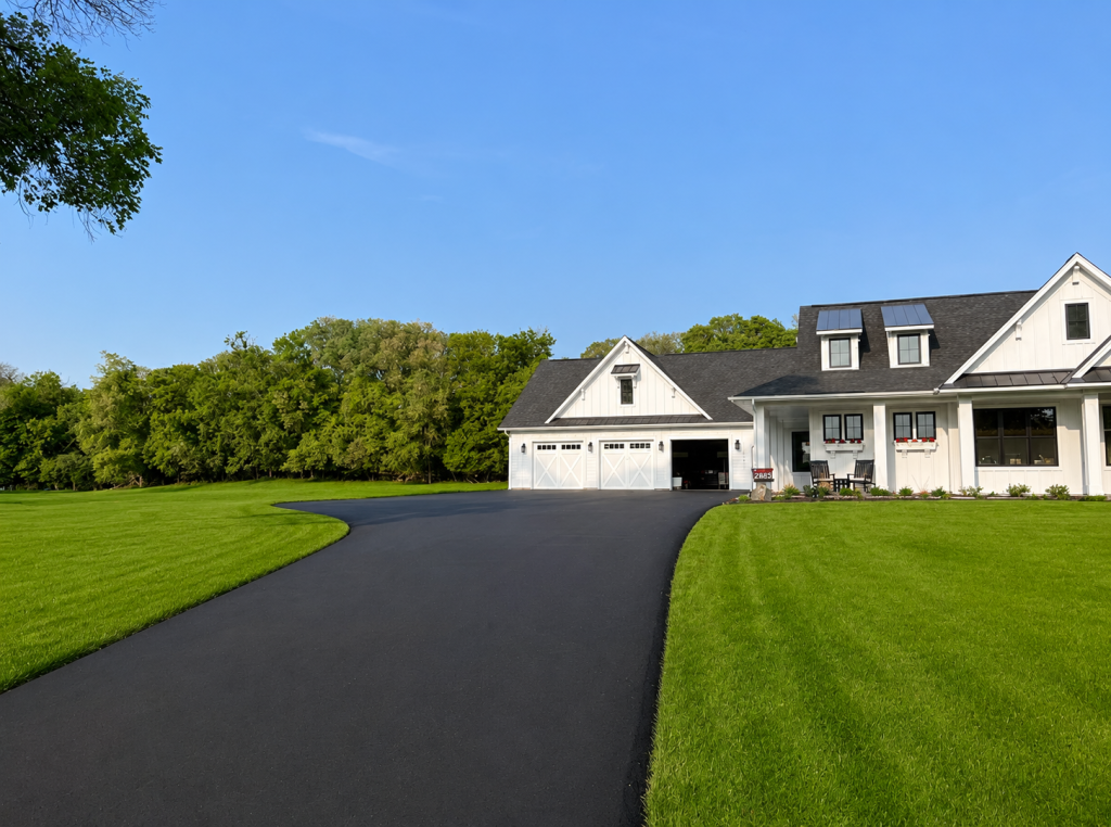 White farmhouse with curved driveway and green lawn