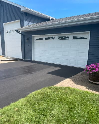 Blue house with white garage and asphalt driveway