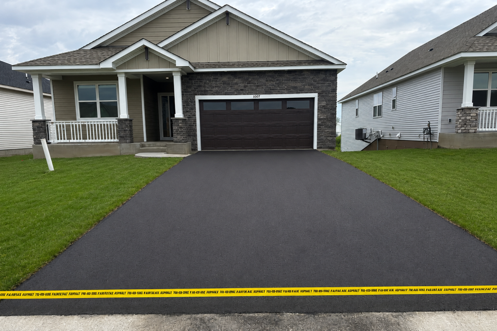 New asphalt driveway in front of suburban home