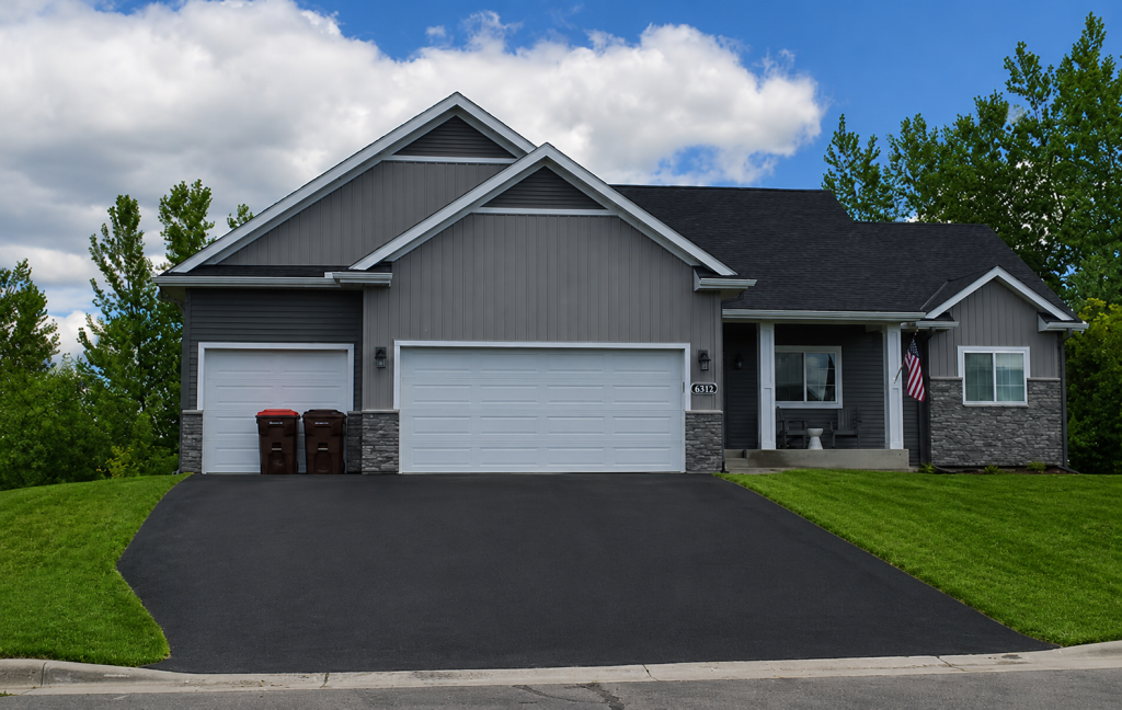 Gray suburban house with two-car garage and driveway